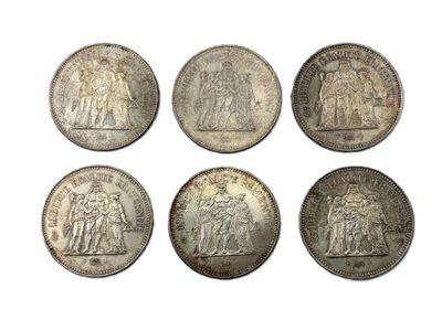 six pièces d'argent de tailles et de formes différentes sur un fond blanc