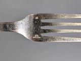 a fork that has a piece of silver on it