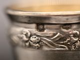 a silver cup that has a design on it