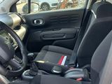the interior of a small car with black seats and a steering wheel