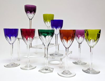 many different colored wine glasses lined up on a table