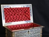 an ornate silver and red box sitting on a black background