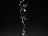 a bronze statue of a woman holding a bird on a pedestal