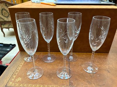 quatre verres à vin posés sur une table en bois, à côté d'une boîte
