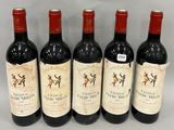 four bottles of wine are lined up on a table