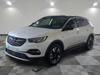 un SUV Opel blanc garé dans un garage au sol carrelé