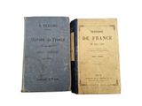 two old books sitting next to each other on a white surface
