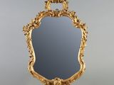 un miroir ouvragé, doté d'un cadre doré et orné d'un oiseau