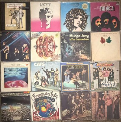 many different album covers on the wall of a room