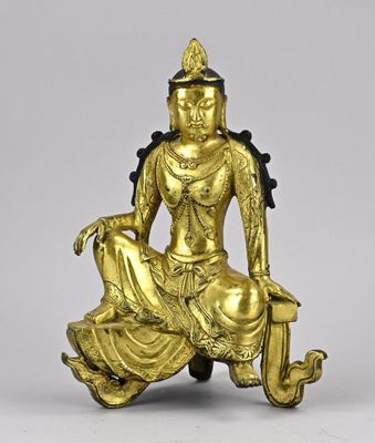 une image représentant une statue en or d'une femme assise sur un rocher
