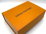 an orange louis vuitton box sitting on a white surface