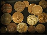 a lot of coins that are in a wooden box