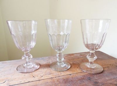 trois verres à vin vides posés sur une table en bois