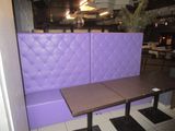 a purple booth with a wooden table in front of it