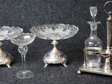trois vases en verre et un support en métal sur fond noir