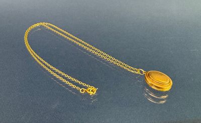 un gros plan d'un collier en or avec une chaîne, posé sur une table