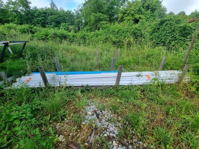 un bateau posé dans l'herbe près d'une clôture