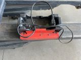 a red and black device attached to the back of a truck