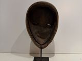 a sculpture of a helmet on a stand on a white surface