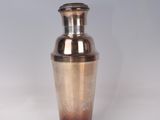 a silver vase with a brown and blue design on it
