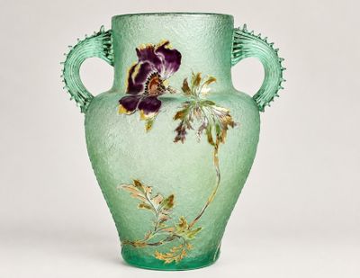 a green vase with a purple flower on it