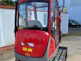 an image of a small red vehicle parked in front of a building