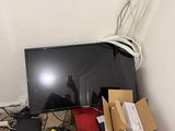 a desk with a monitor, a laptop, and other electronics on it