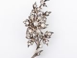 an antique diamond flower broochle on a white background