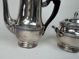 a silver coffee pot and a silver tea pot on a table