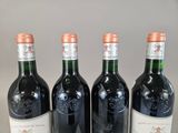 three bottles of red wine are lined up on a table