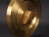 a brass plate on a wooden stand with a black background
