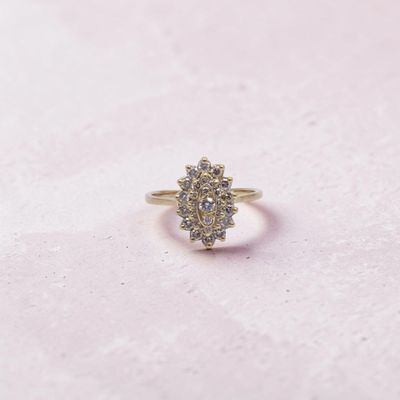 un gros plan d'une bague en or sertie de diamants sur un fond rose