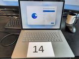 un ordinateur portable posé sur un bureau, avec un calendrier à l'écran