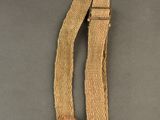 un gros plan d'une ceinture munie d'une boucle métallique sur une surface grise