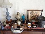 une table sur laquelle se trouvent une lampe, un abat-jour, un tableau et d'autres objets