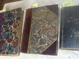 several old books are lined up on a table with tags on them