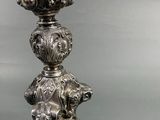 an antique silver candle holder with a bird on top of it