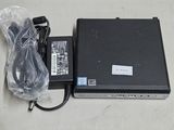 un ordinateur portable ouvert posé sur une table à côté d'un chargeur