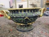 a green and black bowl sitting on top of a table
