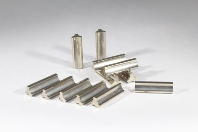 un ensemble de six tiges en acier inoxydable posées sur une surface blanche