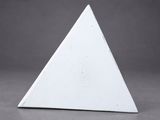 a close up of a white triangular shaped object on a gray surface