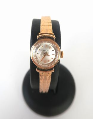 une image représentant une montre-bracelet posée sur un socle, sur fond blanc