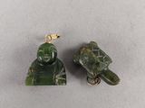 two pieces of green jade with a turtle on top of it