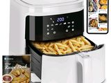 une friteuse à air chaud contenant des frites, avec un livre de recettes à côté