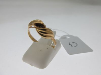 une image d'une bague en or sur une surface blanche avec une étiquette de prix