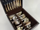a wooden box with silverware in it on a white surface