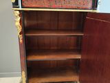 an old wooden cabinet with a red and black design on the front