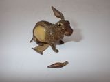 a small metal animal figurine on a white surface