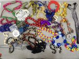 a lot of different necklaces and bracelets on a table