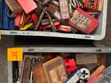 deux bacs remplis d'outils divers, posés par terre